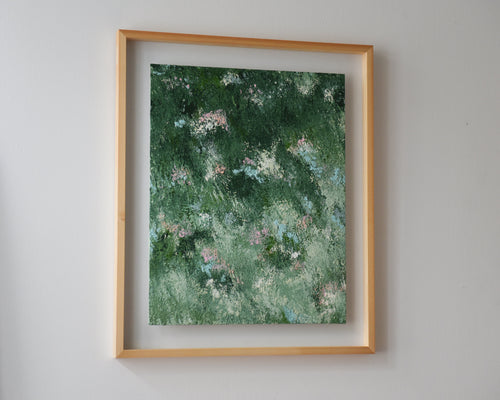 Framed artwork with a green and mint abstract design on a white wall.